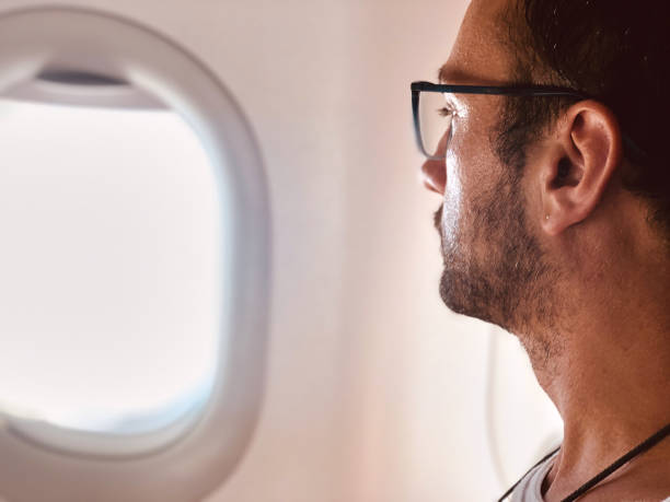 istock Tired / sick passenger in a modern airplane seat next to the window. 1154035487