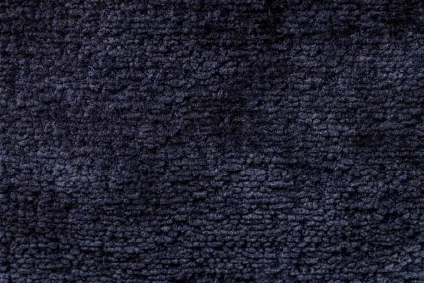 Photo of Navy blue background from soft textile material. Fabric with natural texture.