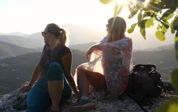istock Female hikers relax above valley below 1154038674