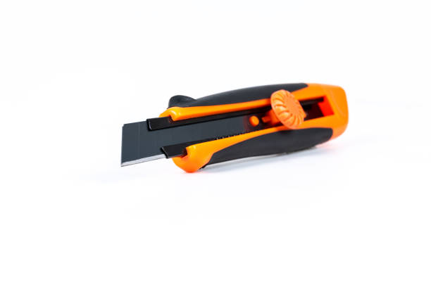 istock Orange and back paper knife or cutter on white background 1154039304