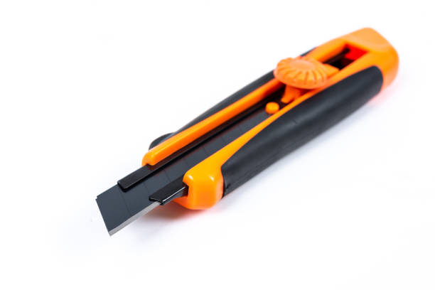 istock Orange and back paper knife or cutter on white background 1154039308