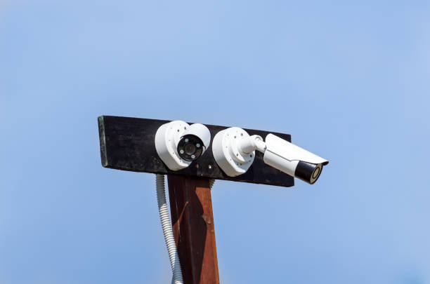 istock Security cctv cameras in front of blue sky 1154042307