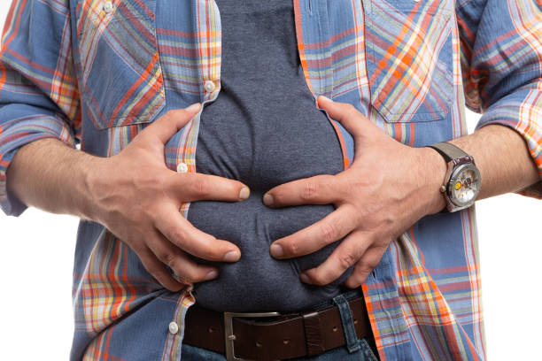 istock Closeup of bloated man touching belly 1154042421