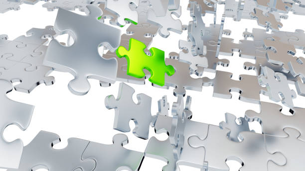 istock Several Chaotic Grey Puzzle pieces with many holes and one big Green piece 1154043693