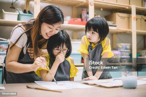 Die Asiatische Chinesische Kunstklehrerin Unterrichtet Ihre 2 Kunststudenten Beim Zeichnen In Ihrer Kunstklasse Stockfoto und mehr Bilder von Kind