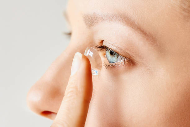 Young woman puts contact lens in her eye. Eyewear, eyesight and vision, eye care and health, ophthalmology and optometry concept. Close up human eye close up eyeball side view stock pictures, royalty-free photos & images