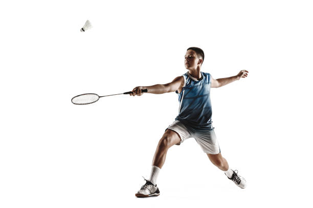 Little boy playing badminton isolated on white studio background
