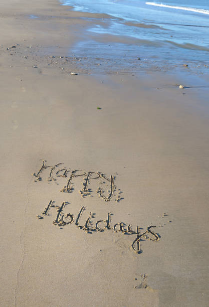 istock happy holidays written on the sand at low tide 1154046199