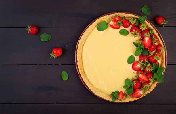 tarte aux fraises et crème fouettée décorée de feuilles de menthe sur fond sombre. vue de dessus - food staple dairy product ricotta tart photos et images de collection