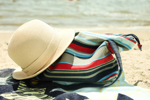 istock striped beach bag and straw hat 1154048974