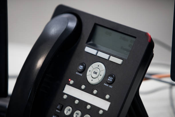 istock close up soft focus on telephone devices at office desk. 1154048988