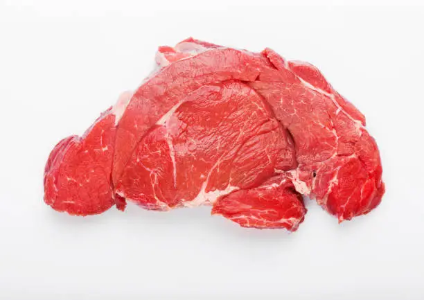 Fresh raw organic slice of braising steak fillet on white.