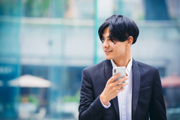 istock Young man using smart phone in cafeteria at sunny day 1154051401