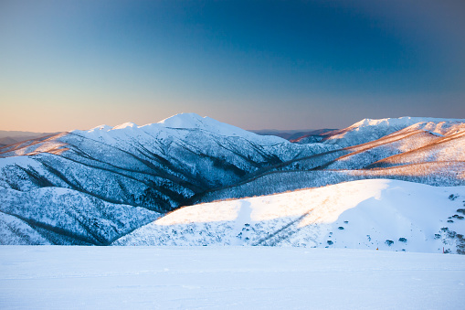 A well active, athletic Caucasian trail runner running outside in winter mountains.