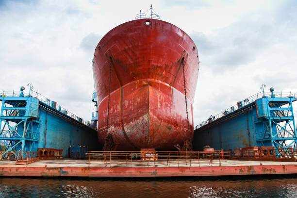 Huge red tanker is in floating dock Huge red tanker is under repairing in blue dry dock. Front view. Shipyard of Varna, Bulgaria dry dock stock pictures, royalty-free photos & images