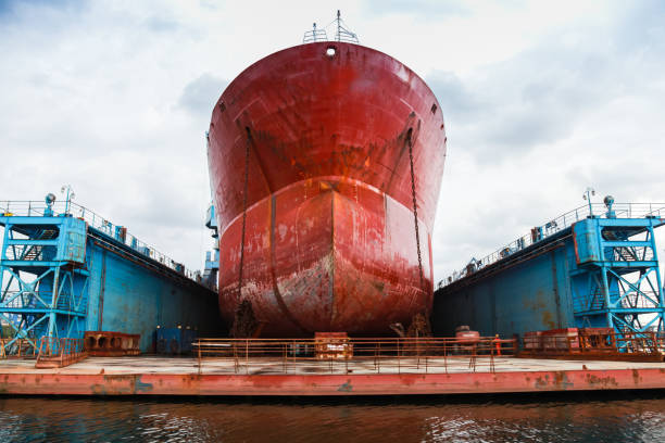 Huge red tanker is in floating dock Huge red tanker is under repairing in blue dry dock. Front view. Shipyard of Varna, Bulgaria dry dock stock pictures, royalty-free photos & images