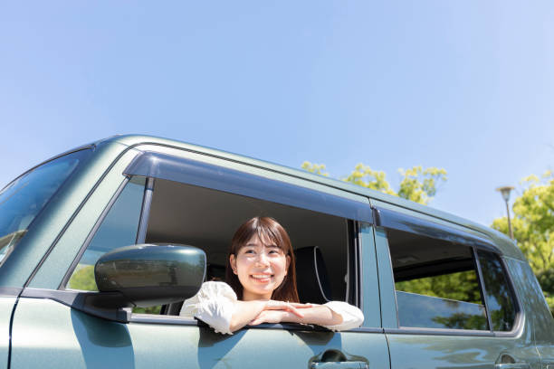 woman looking at the view from the car window - driving car drive women imagens e fotografias de stock