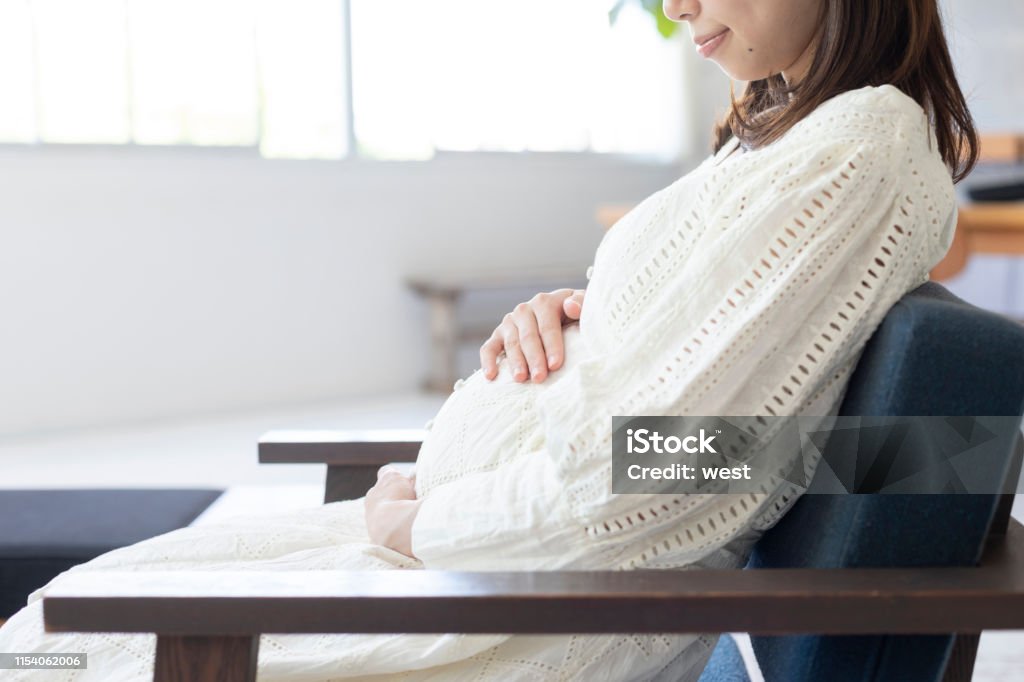 Barriga de sucção da mulher gravida no quarto - Foto de stock de Grávida royalty-free