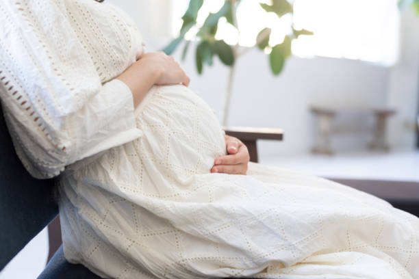 barriga de sucção da mulher gravida no quarto - sentar se pose - fotografias e filmes do acervo