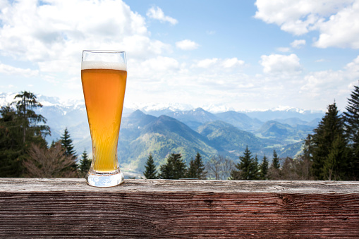 Wheat beer glass in front of mountain view panorama in Bavaria