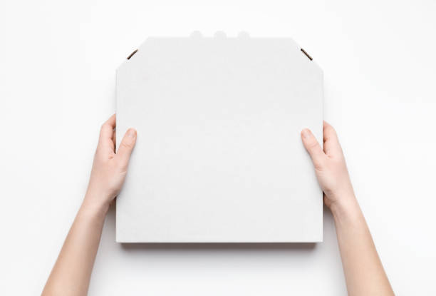 istock Courier holding pizza box in hands isolated on white 1154068597