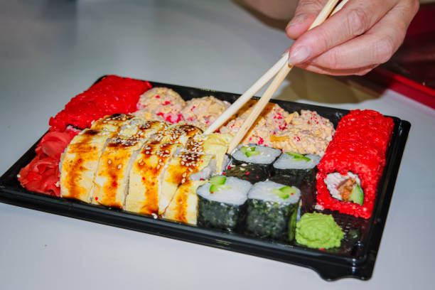 istock Sushi set with different roles on a black plate close-up. 1154069073