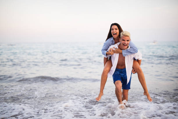 istock Happy young couple having fun and love on the beach 1154071442
