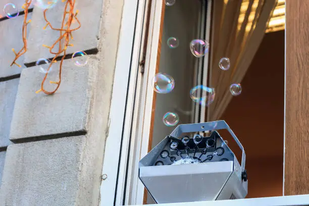 Photo of Machine generator for soap bubbles stands on window