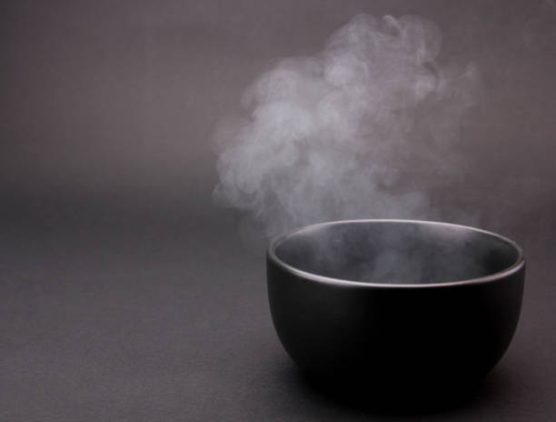 istock Bowl of hot soup on black background. 1154075850