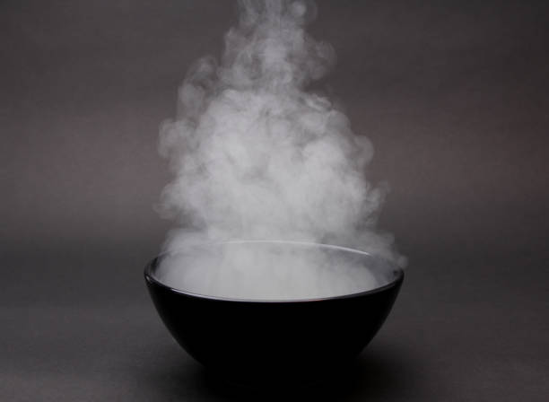 istock Bowl of hot soup on black background. 1154075877