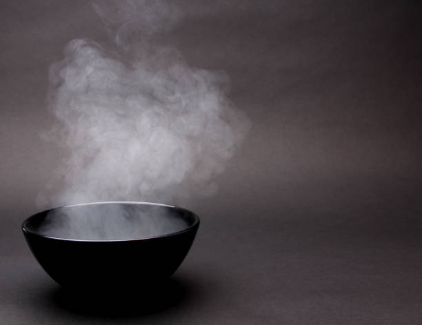 istock Bowl of hot soup on black background. 1154075886