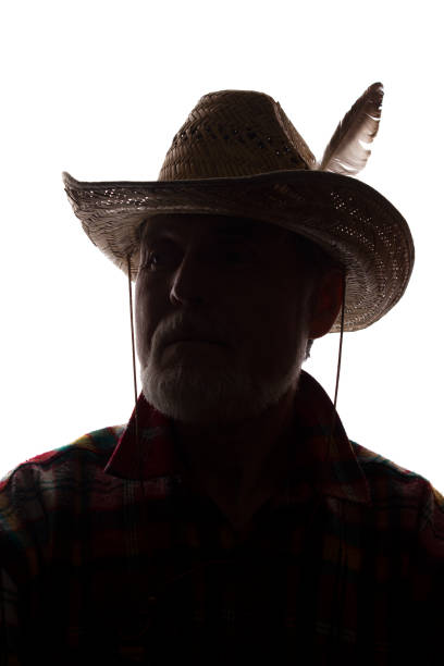 istock Old man in cowboy hat, front view - dark close-up silhouette 1154076370