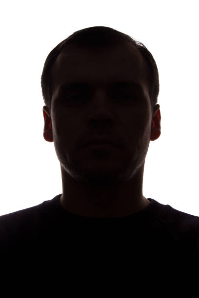 istock Portrait of a young man, front view - dark isolated silhouette 1154077273