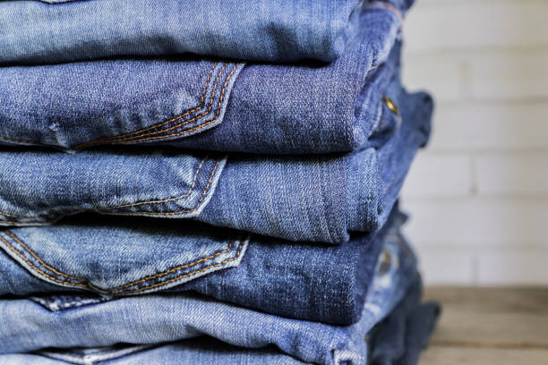 Stack of blue jeans on wooden shelf. Beauty and fashion clothing concept Stack of blue jeans on wooden shelf. Beauty and fashion clothing concept jeans stock pictures, royalty-free photos & images