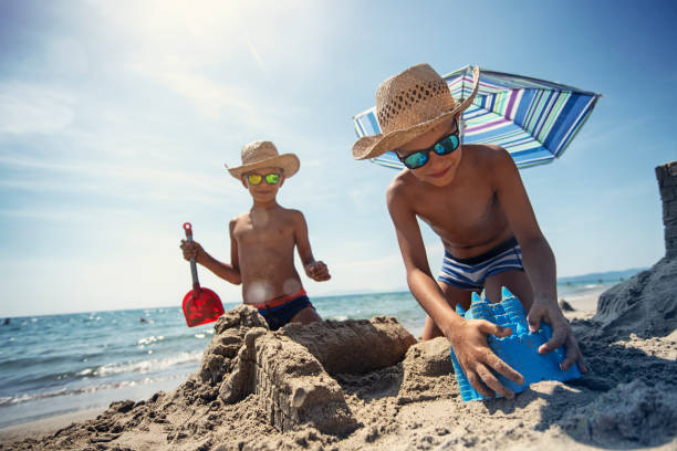 istock Little boys building a sandcastle on beach 1154077879