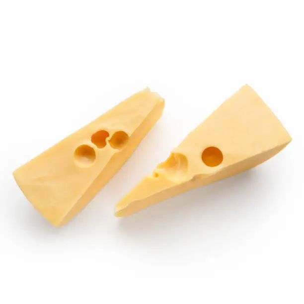 Swiss cheese pieces on white background, top view