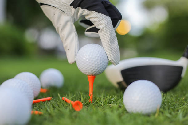 istock Hand hold golf ball with tee on course, close-up 1154080457