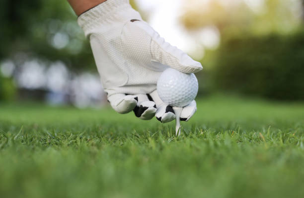 istock Hand hold golf ball with tee on course, close-up 1154080459