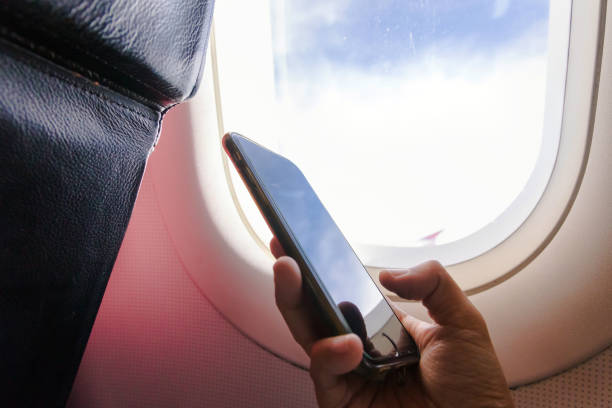 istock Woman hand holding a smartphone on board; typing text message during flight. 1154080643