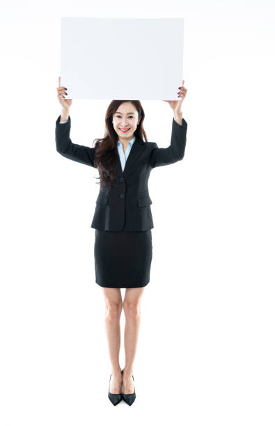 empresaria sosteniendo pancarta en blanco sobre fondo blanco - businesswoman advertise placard advertisement fotografías e imágenes de stock