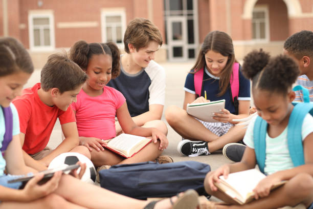 gruppe von schulkindern, freunde, die gemeinsam auf dem campus studieren. - mittelschule bücher stock-fotos und bilder