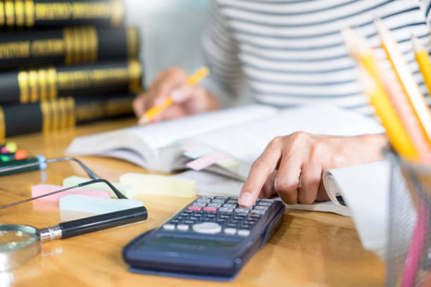istock Midsection Of Woman Using Calculator At Office 1154087225