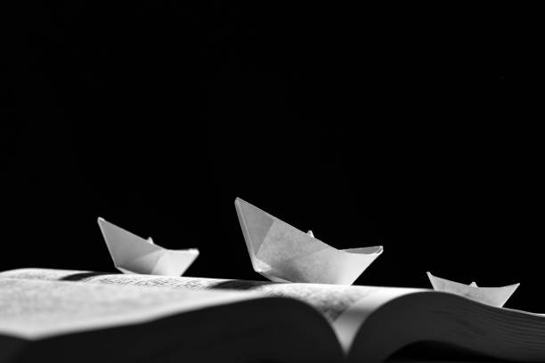 istock Paper boats on the opened book 1154090279