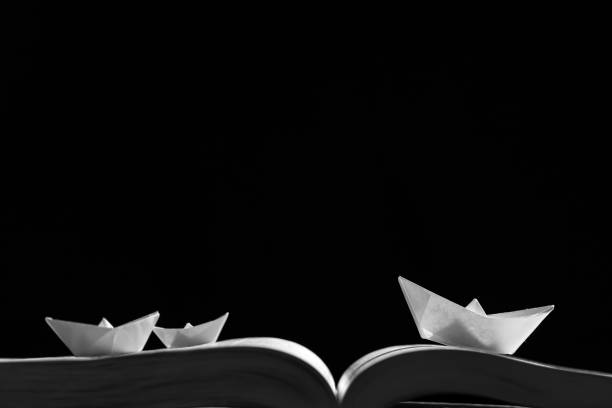 istock Paper boats on the opened book 1154090281