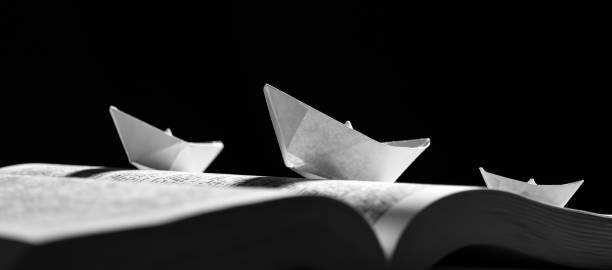 istock Paper boats on the opened book 1154090283