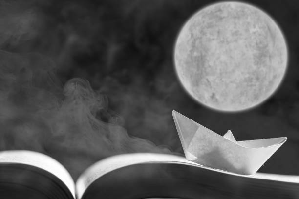 istock Paper boat on the opened book 1154090297