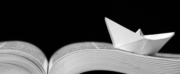 istock Paper boat on the opened book 1154090308