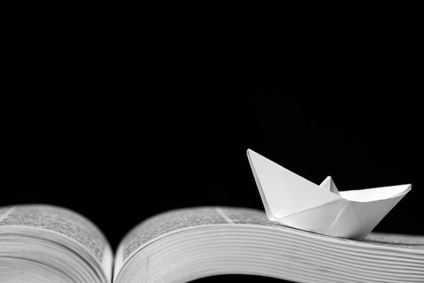 istock Paper boat on the opened book 1154090311