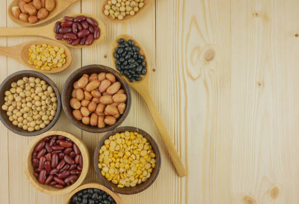 Flat lay,top view assorted beans including red bean,soybeans,black beans,mung beans on brown,beige wooden background with copy space