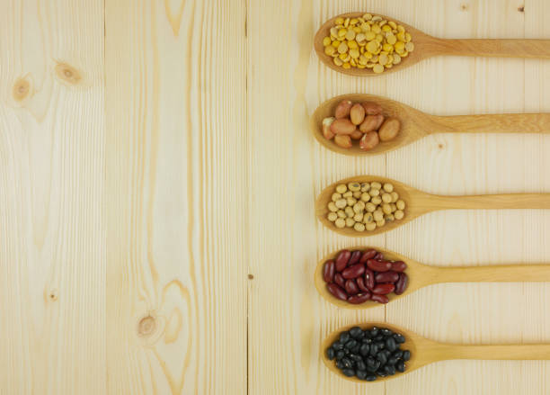 Flat lay,top view assorted beans including red bean,soybeans,black beans,mung beans on brown,beige wooden background with copy space